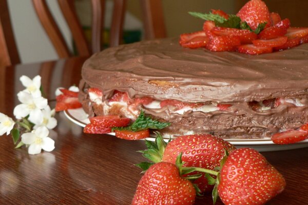 Postre de fresa y chocolate en una mesa de madera