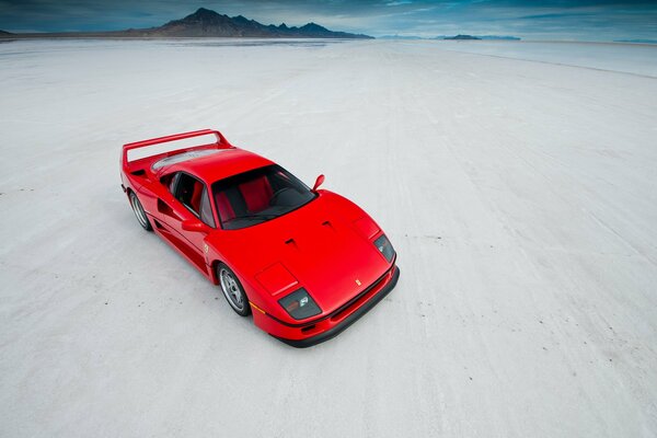 Red ferrari on white sand