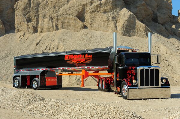 A long truck is parked in the desert