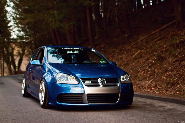 On the autumn road - blue Volkswagen Golf