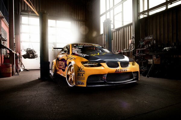 Voiture orange BMW M3 dans le garage