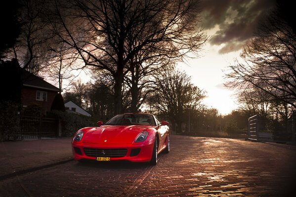 On the autumn street, a red Ferrari sports car