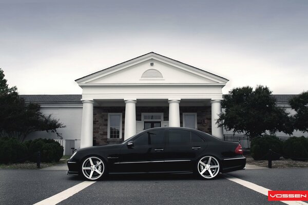 Schwarzer Mercedes Benz auf dem Hintergrund eines schönen Hauses