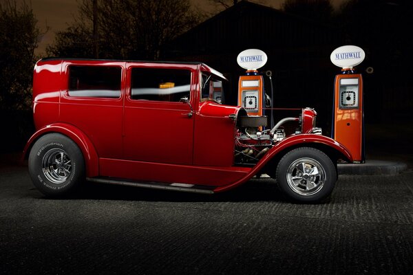 Coche rojo Ford. Ford cerca de la gasolinera