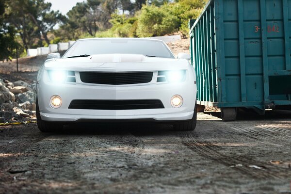 White Chevrolet Camaro with headlights on