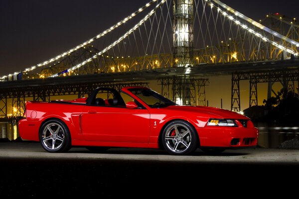 Rosso ford mustang di notte di profilo