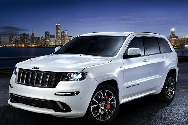 Jeep grand cherokee en medio de una ciudad nocturna