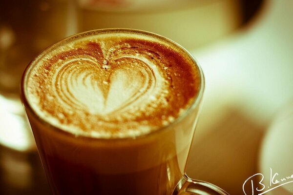 Corazón en una película de café en un vaso de vidrio