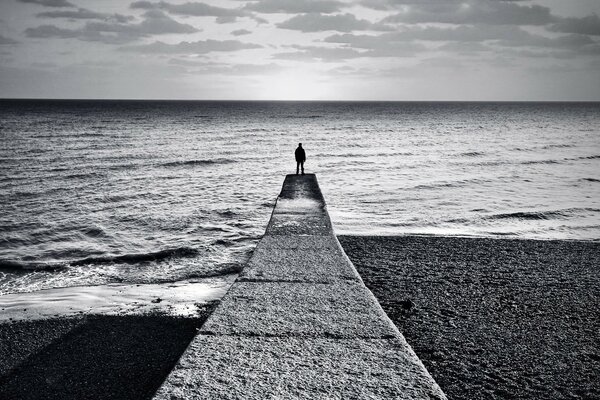 Fond noir et blanc, l homme sur le quai s étendant à l horizon