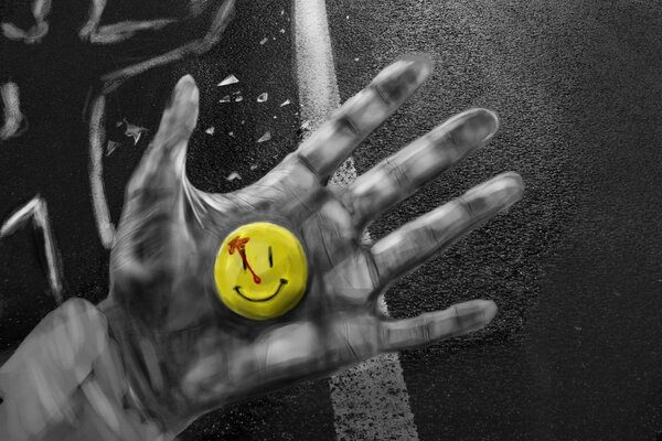 Cara sonriente amarilla en la mano