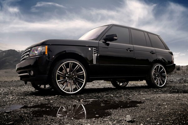 A tuned land Rover standing against the sky