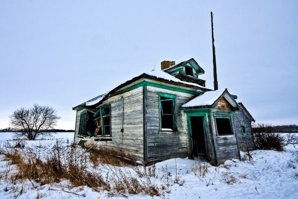 A ruined house in a snow-covered field