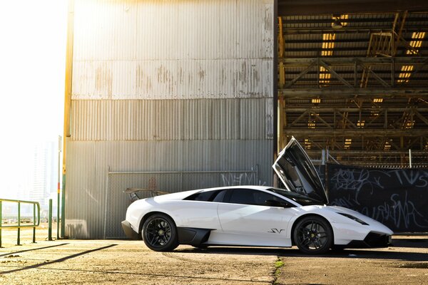 Белый компактный lamborghini murcielago под сияющим солнцем