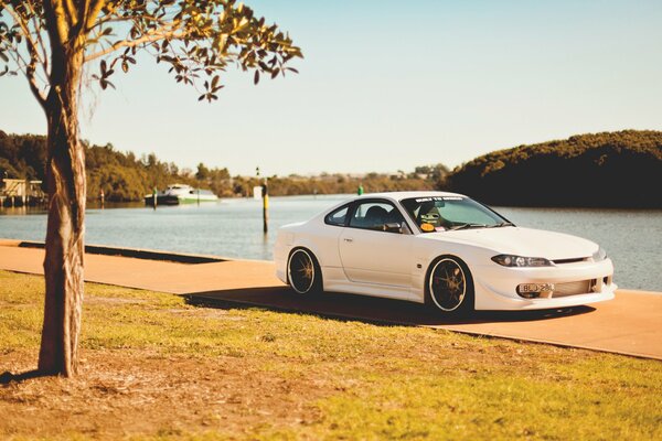 White nissan on a sunny day on the embankment