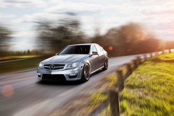 Silver Mercedes C63 AMG in motion on the road