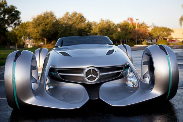 Silbernes Mercedes-Auto auf einem Hintergrund von Bäumen