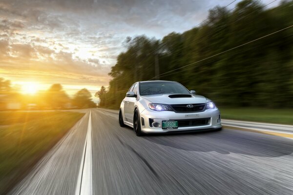 Subaru in motion at sunrise