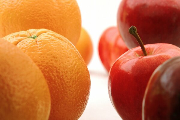 Pomarańczowe pomarańcze po lewej i czerwone jabłka po prawej