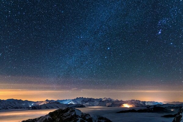 Cielo estrellado y montañas nevadas