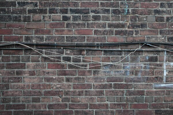 Câble accroché sur un mur de briques