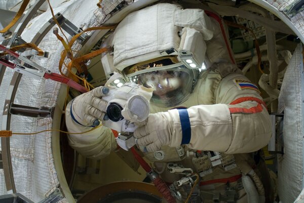 Cosmonaut in an orlan spacesuit with a camera