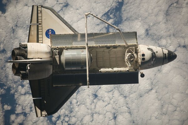 Un transbordador volando por encima de las nubes