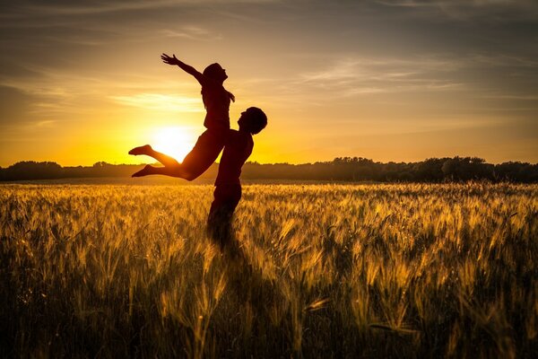 Couple d amoureux sur fond de coucher de soleil sur le terrain