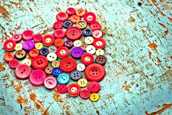 Multicolored heart made of bright buttons