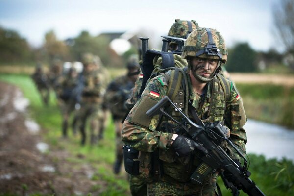 Soldados alemanes en camuflaje van con ametralladoras