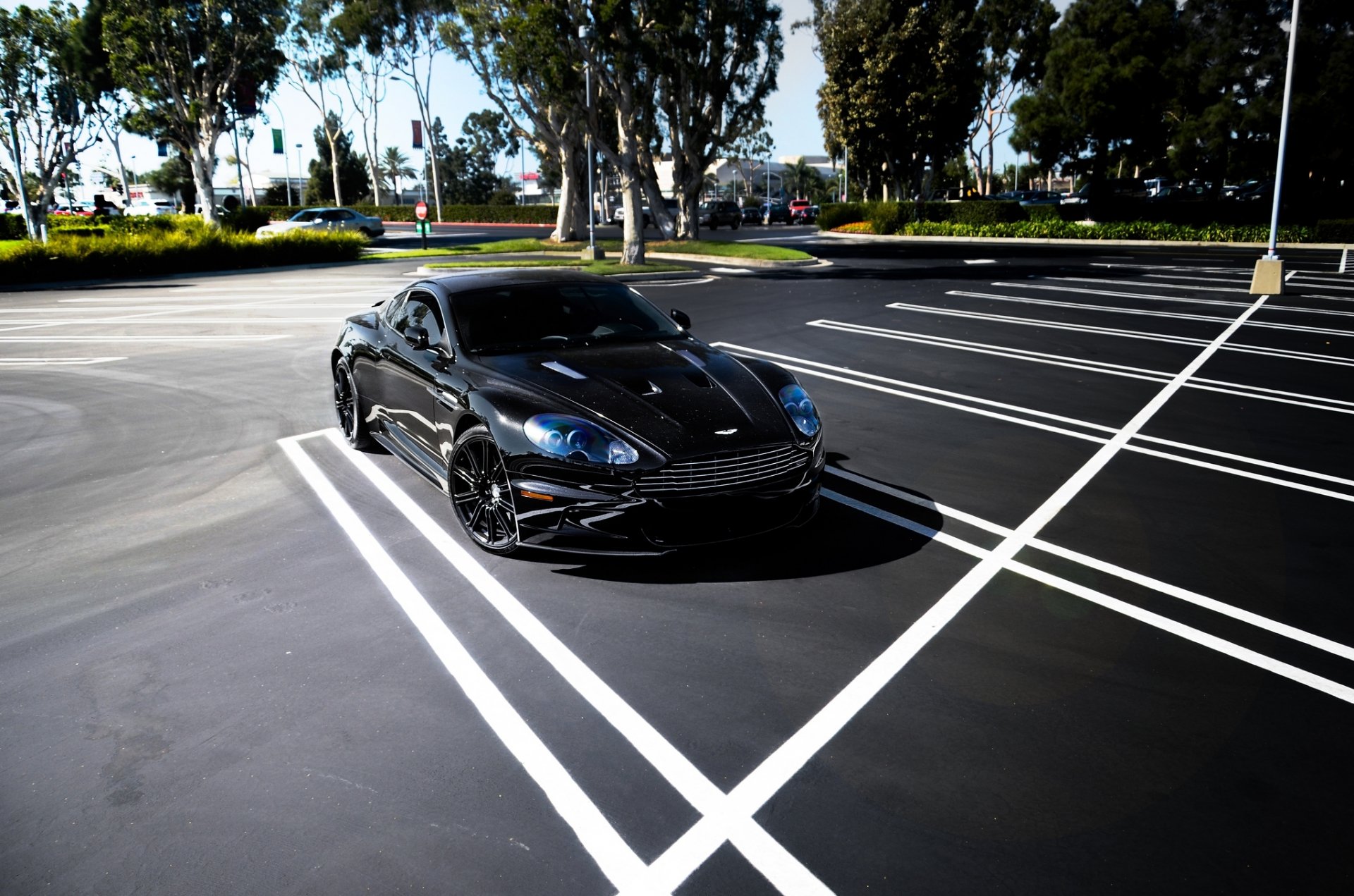 aston martin dbs noir aston martin dbs ombre parking arbres