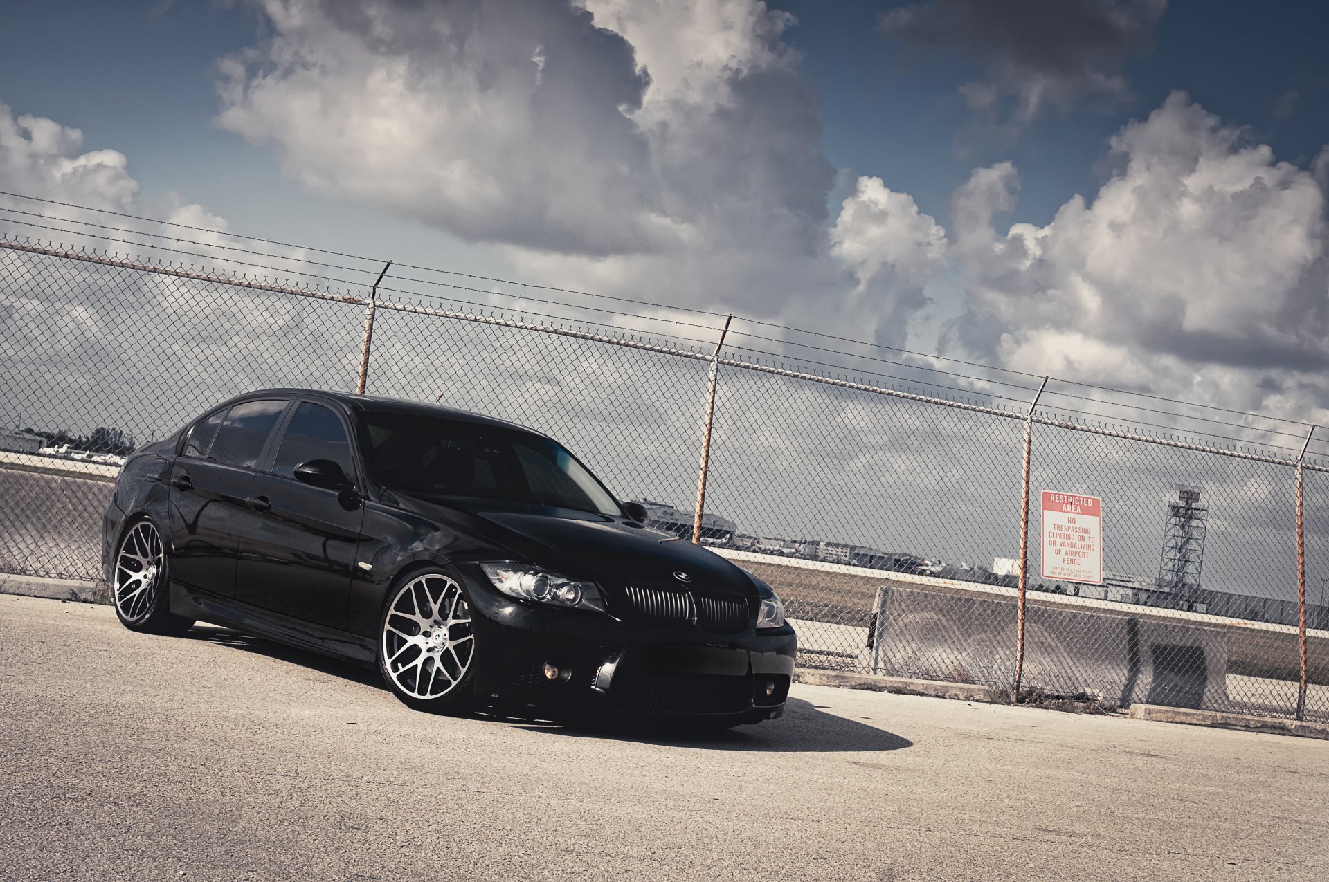 bmw 3er 335i schwarz bmw vorderseite zaun betonblöcke himmel wolken