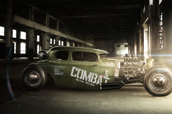 The green car is in the hangar