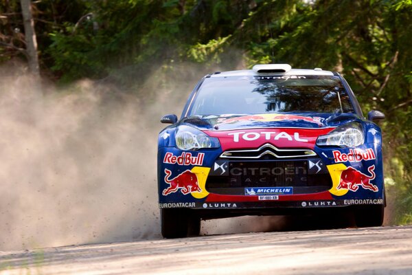 Citroen rally goes into a turn with a rise of dust
