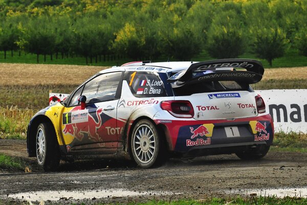 Une voiture de sport de la marque Citroën passe la piste dans la boue