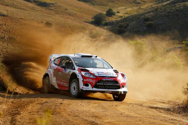 Ford fiesta conduce fuera de la carretera en clubes de polvo