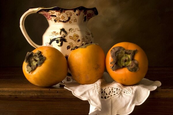 Still life of a jug and persimmon on a napkin