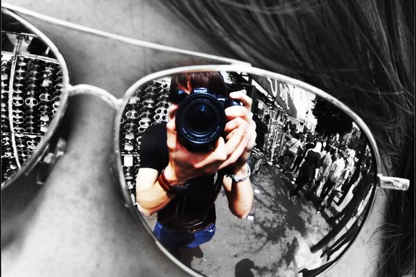 Dans les verres des lunettes, le reflet du photographe tenant l objectif