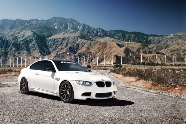 Detrás del blanco BMW molinos de viento y montañas