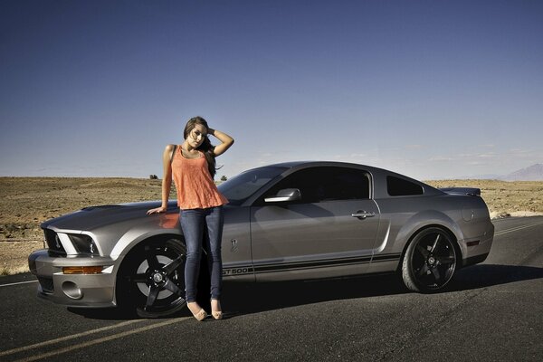 Belle fille à côté de la Mustang Ji TI 500 dans le désert