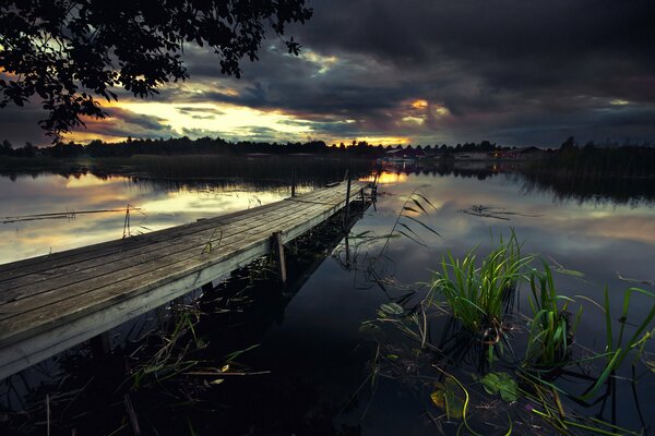 Abendliche Flusslandschaft mit Holzbrücke