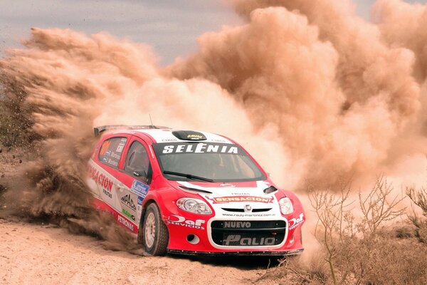 Rally in the desert red fiat raised a storm of sand