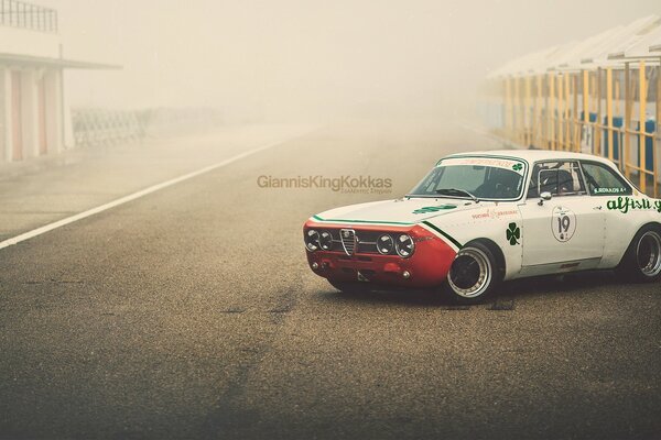 White Alfa Romeo on the road in the fog