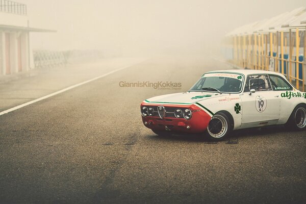 Alfa Romeo blanco en la carretera en la niebla