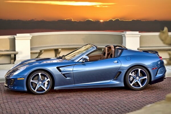 Niebieski Ferrari kabriolet superamerica 45 o zachodzie słońca