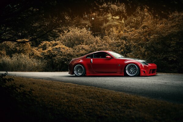 Red Nissan 350z with a body kit on the road