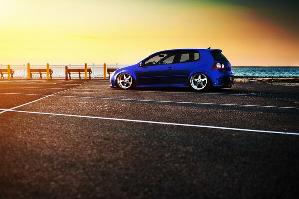 Blauer Volkswagen Golf an der Uferpromenade