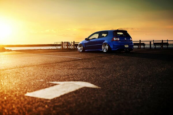 Blue Volkswagen car near moya on sunset background