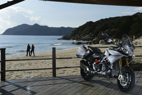 Zdjęcie motocykla na plaży na tle morza i skał