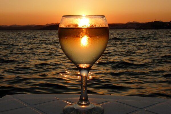 Vue du coucher de soleil à travers le prisme de l eau dans le verre