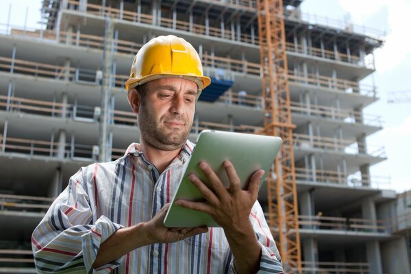 Ein Mann in einem Helm hält ein Tablet